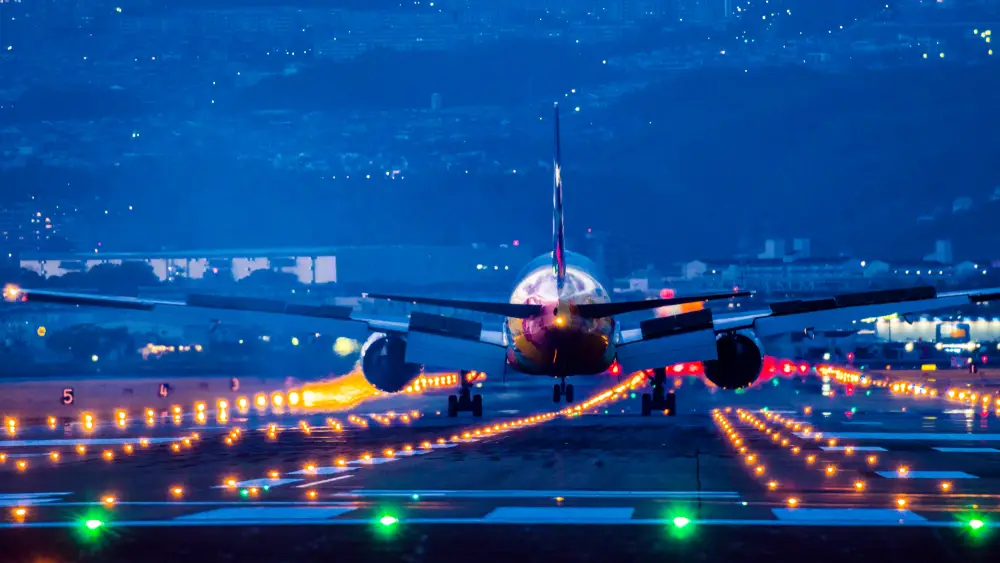 Ο νυχτερινός διάδρομος του αεροδρομίου φωτίστηκε με αεροπλάνο να ταξιδεύει στον διάδρομο προσγείωσης για έναν οδηγό που ρωτά τι είναι μια πτήση με κόκκινα μάτια