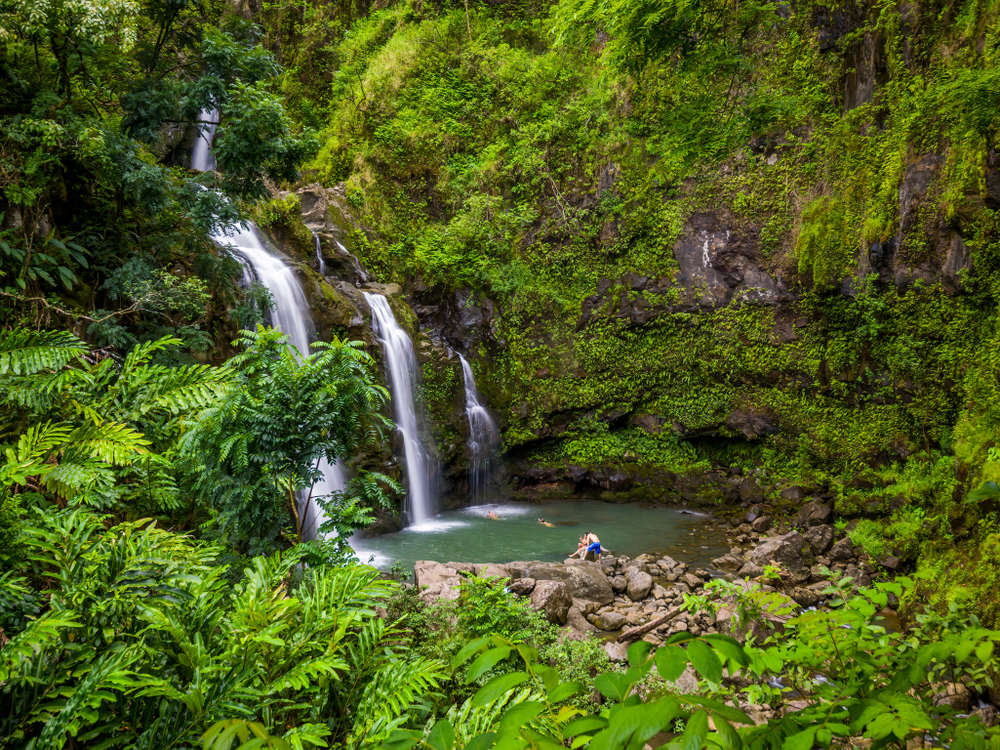 Three Bears Falls on the Road to Hana in Maui περιτριγυρισμένο από πράσινο για ένα τμήμα που δείχνει σε ποιο νησί να μετακομίσετε στη Χαβάη για έναν κινούμενο οδηγό