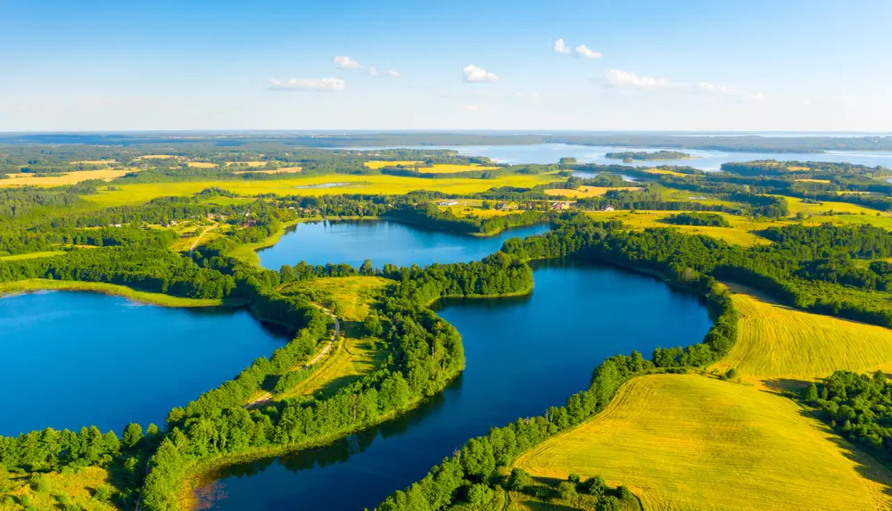 Aerial view of several lakes where their banks are surrounded by trees.