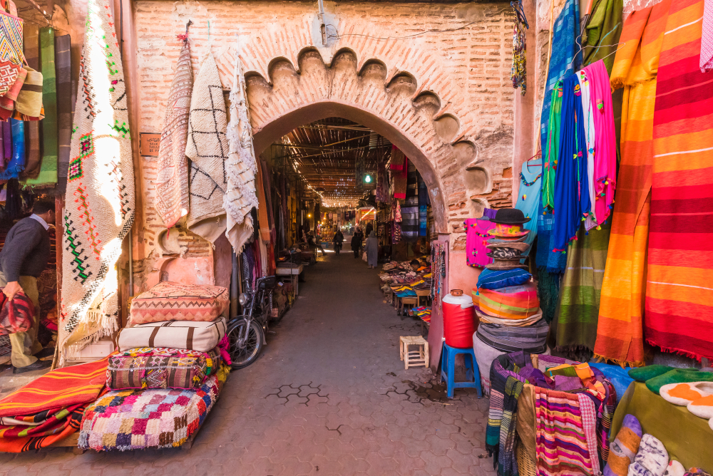An entrance to the market where vibrant colored fabrics are displayed.