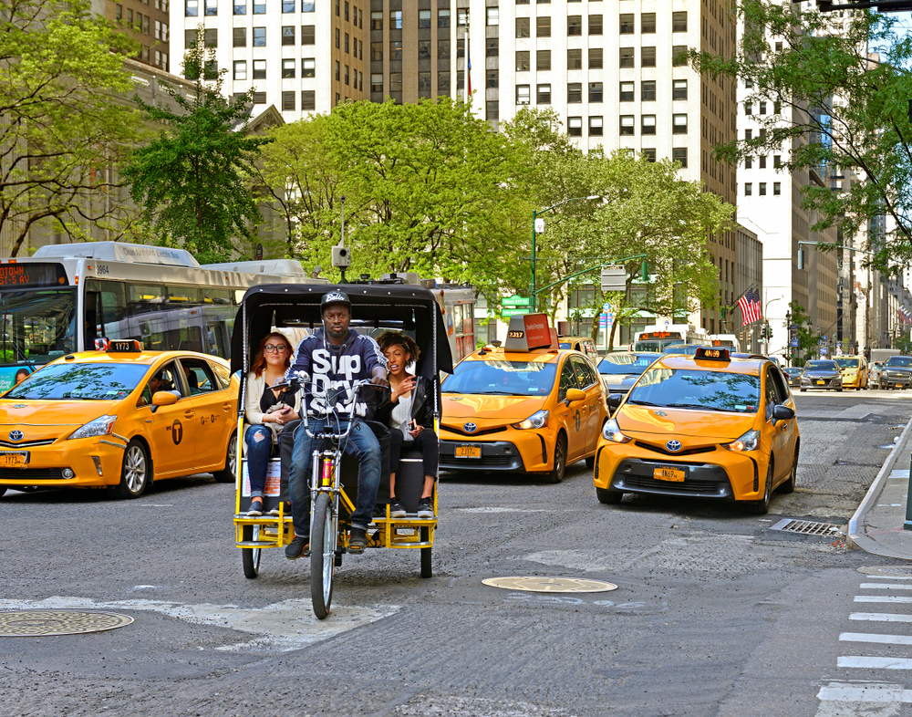Άτομα που οδηγούν στο πίσω μέρος ενός ποδοσφαίρου rickshaw για έναν οδηγό με τίτλο Is New York City Safe to Visit