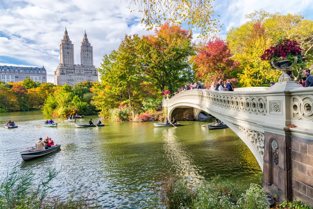 Το Central Park απεικονίζεται με ανθρώπους σε βάρκες κάτω από τη γέφυρα για μια ανάρτηση με τίτλο Is NYC Safe to Visit