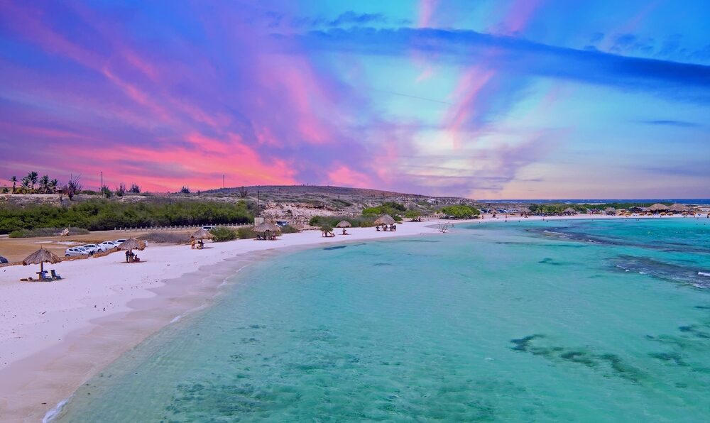 Πανέμορφο ροζ ηλιοβασίλεμα πάνω από την παραλία Baby στην Αρούμπα κατά τη συνολική καλύτερη στιγμή για να επισκεφθείτε την Καραϊβική