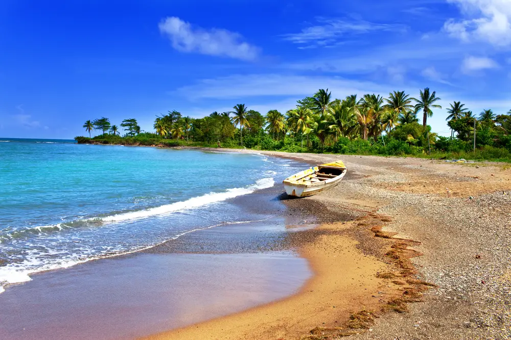 Αμμώδης και βραχώδης παραλία στην Τζαμάικα που απεικονίζεται κατά τη διάρκεια της συνολικής λιγότερο πολυάσχολης περιόδου για να επισκεφθείτε την Καραϊβική με ένα μοναχικό σκάφος και κανέναν τριγύρω