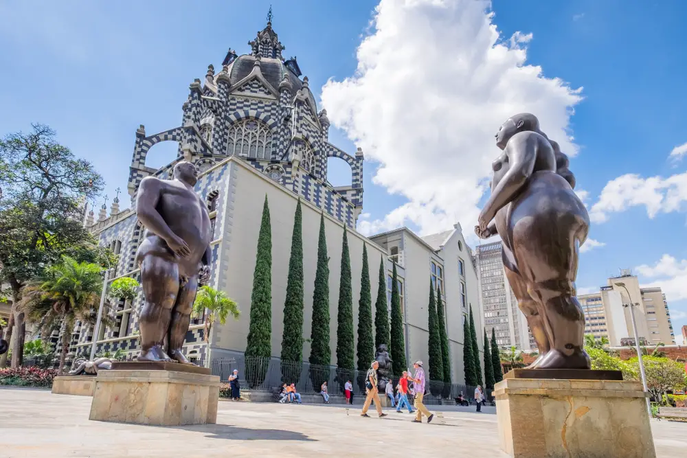 View of the empty Plaza Botero with a statue of a portly man during the cheapest time to visit Medellin