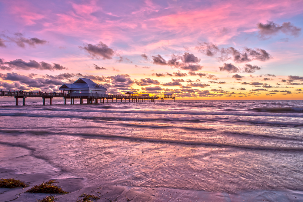 Πορτοκαλί και ροζ ουρανός πάνω από το νερό κατά την καλύτερη στιγμή για να επισκεφθείτε το Clearwater της Φλόριντα