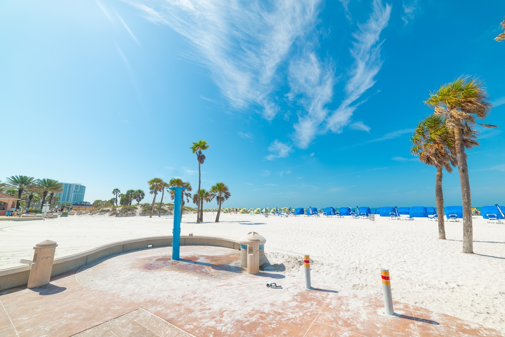 Είσοδος σε μια άδεια παραλία που απεικονίζεται την καλύτερη στιγμή για να επισκεφθείτε το Clearwater, FL με λευκή άμμο και σκούρο μπλε ουρανό πάνω