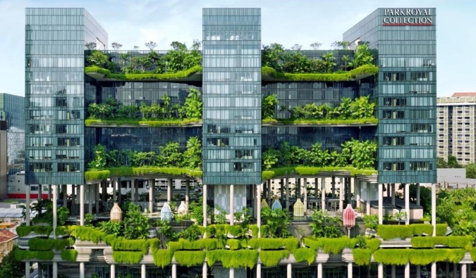 Το εξωτερικό του PARKROYAL COLLECTION Pickering, ενός ξενοδοχείου 5 αστέρων στη Σιγκαπούρη, καλυμμένο με πλούσια φυτά που ρέουν από τα μπαλκόνια