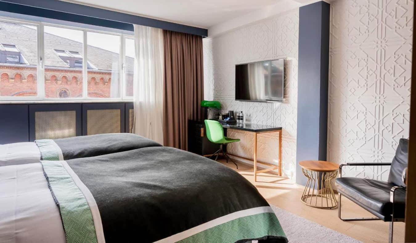 Ένα κομψό δωμάτιο ξενοδοχείου με ένα μεγάλο κρεβάτι στο Hotel Skt Petri στην Κοπεγχάγη της Δανίας