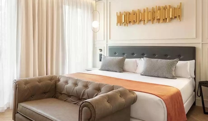 Ένα χρυσό κομμάτι διακόσμησης κρέμεται πάνω από ένα διπλό κρεβάτι με ένα ερωτικό κάθισμα στους πρόποδες του κρεβατιού στο ξενοδοχείο Catalonia Goya στη Μαδρίτη, Ισπανία
